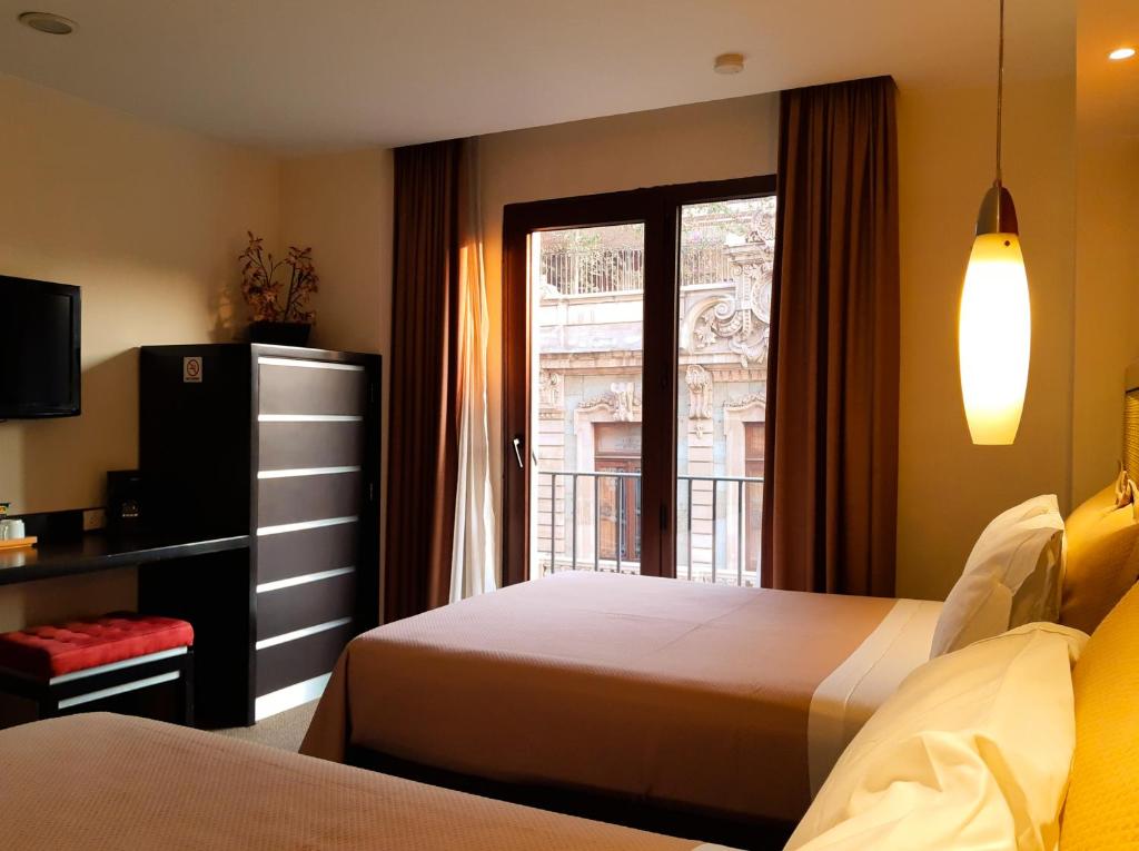 墨西哥城卡特迪尔酒店的酒店客房设有两张床和窗户。