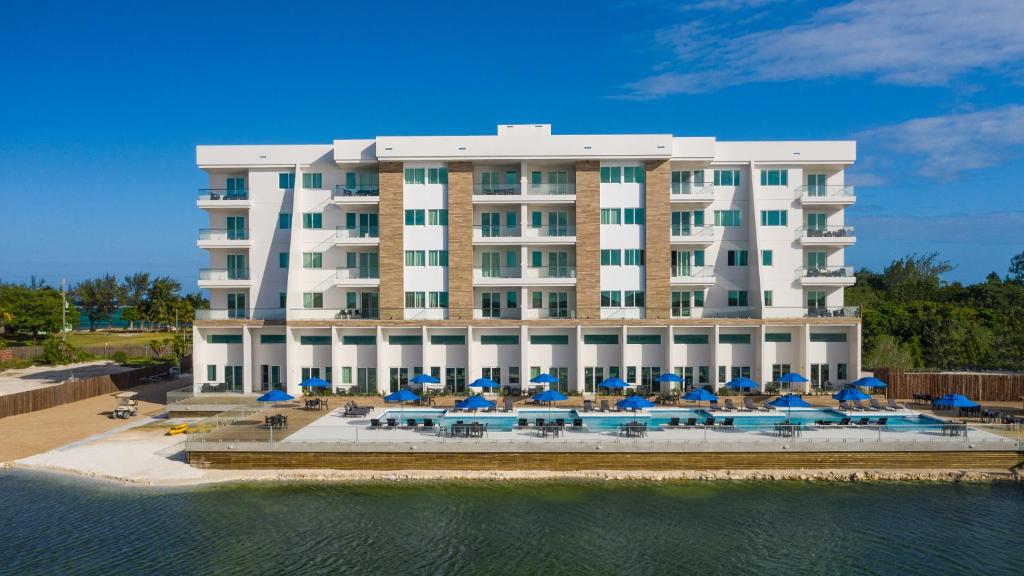 圣佩德罗Sunset Caribe Belize的大型酒店,设有游泳池、遮阳伞和椅子