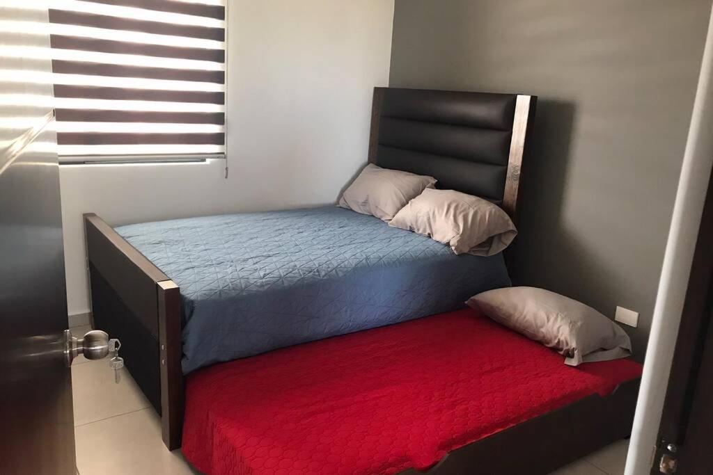 马萨特兰Palmilla residencial departamento en zona privada的一间卧室配有一张带红色毯子的床