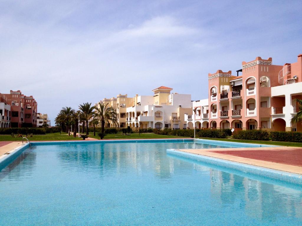 萨伊迪耶Appartement Résidence Alwaha Saidia的一座大型游泳池,位于部分建筑前