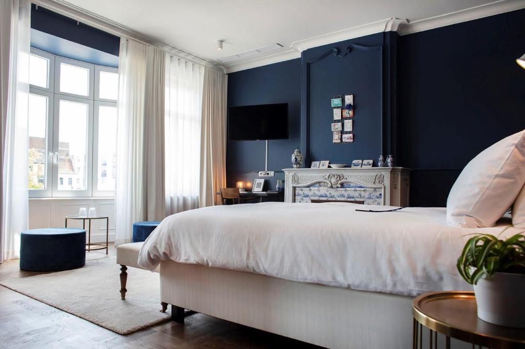 科特赖克Broel4的一间卧室设有一张大床和蓝色的墙壁