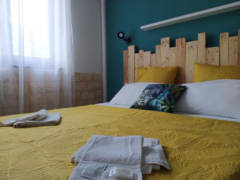 圣塔·马里亚·迪·帕尔玛Bed & Breakfast Pintadera的一间卧室配有一张黄色的床和木制床头板
