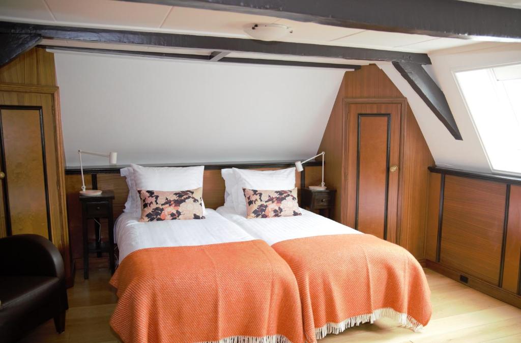 哈林亨咖瑞基恩民宿旅馆的一间卧室配有一张带橙色毯子的床
