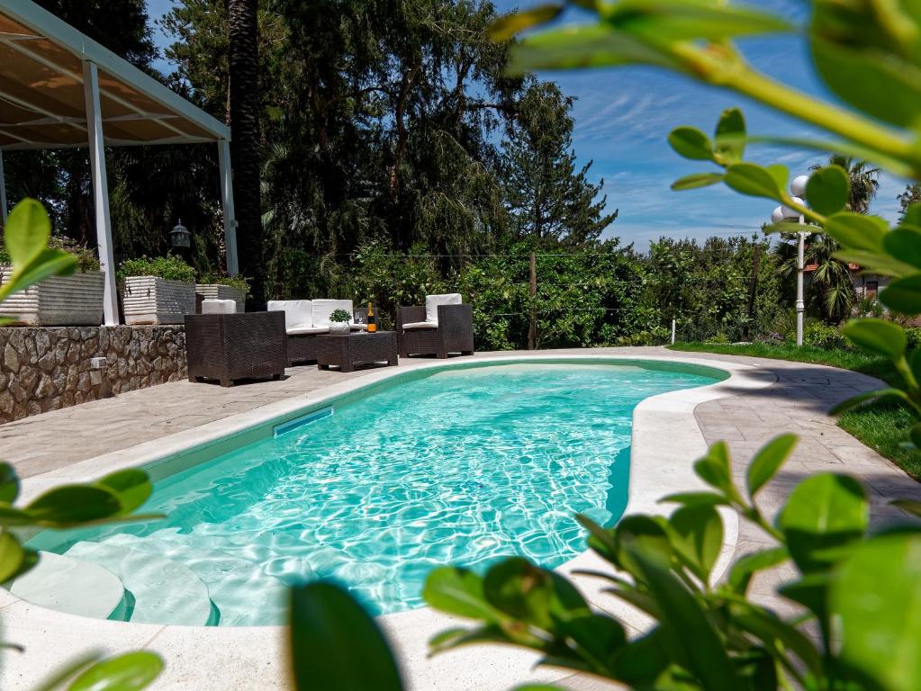 卡斯特拉玛雷帝斯达比亚Du Parc Boutique Home的庭院内一个带椅子和桌子的游泳池