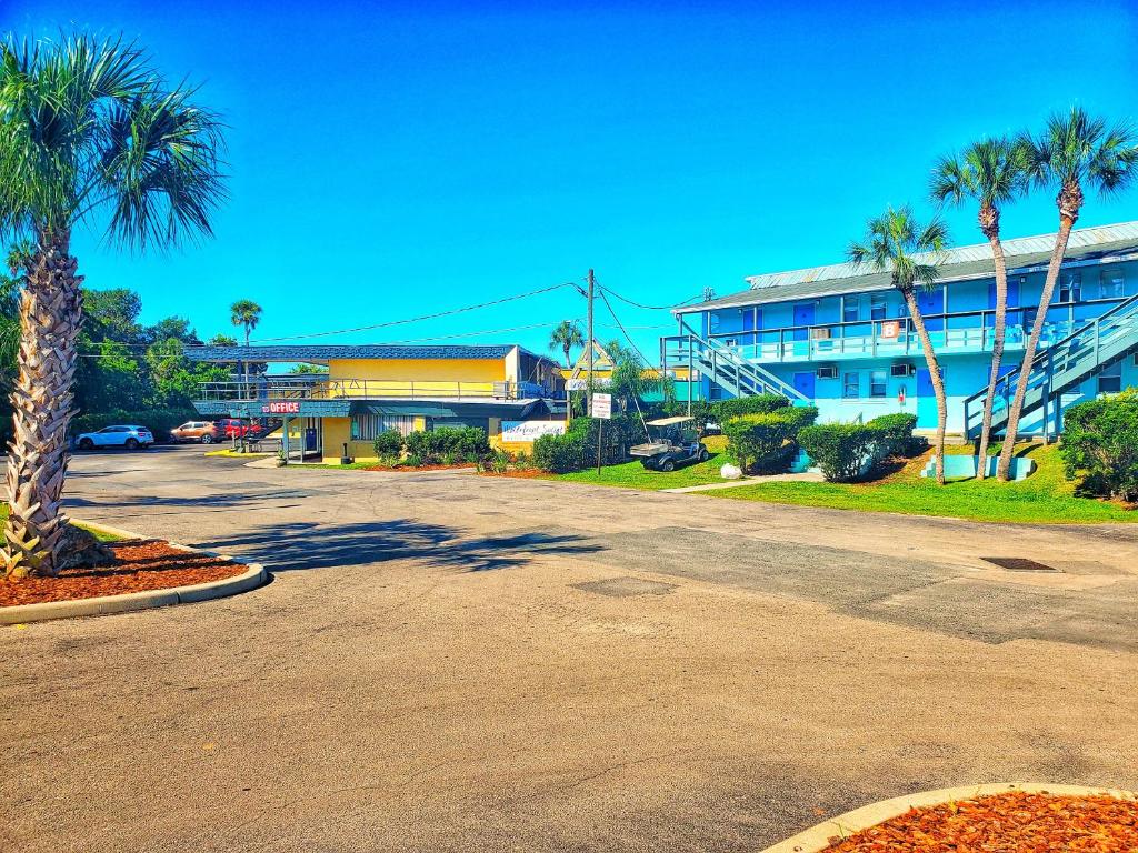 克里斯特尔里弗波特和马里纳酒店的棕榈树建筑前的一个空停车位