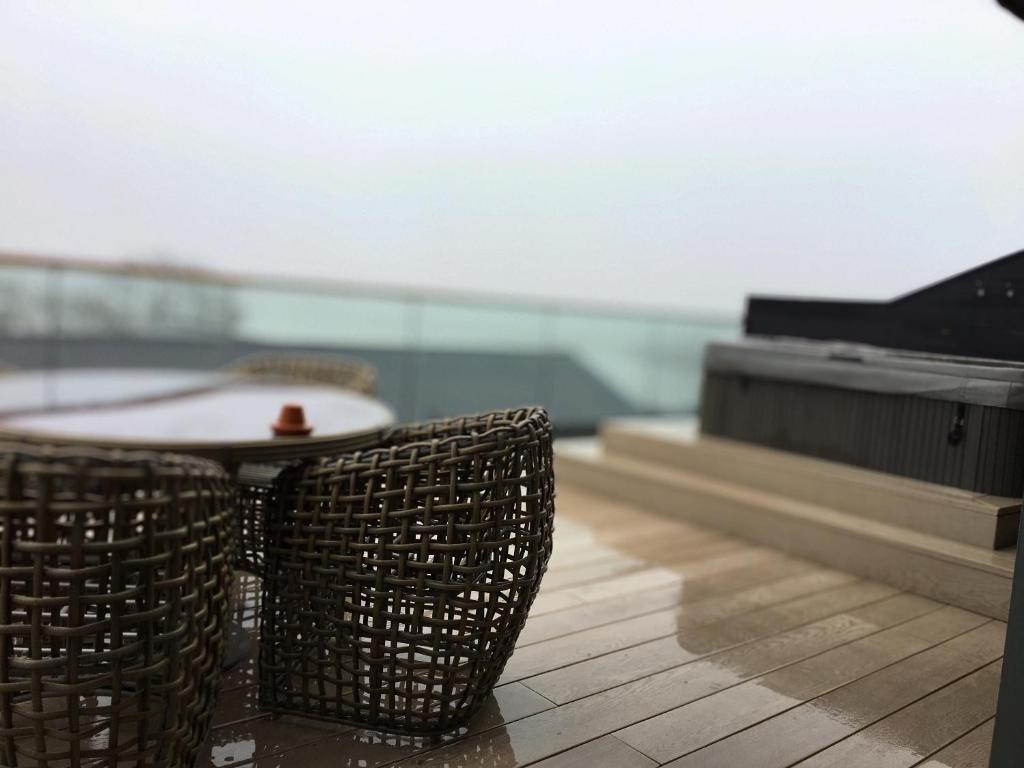 卡马森5 Luxury Lodge with beautiful views of the Taf Estuary的地板上配有两把藤椅和一张桌子