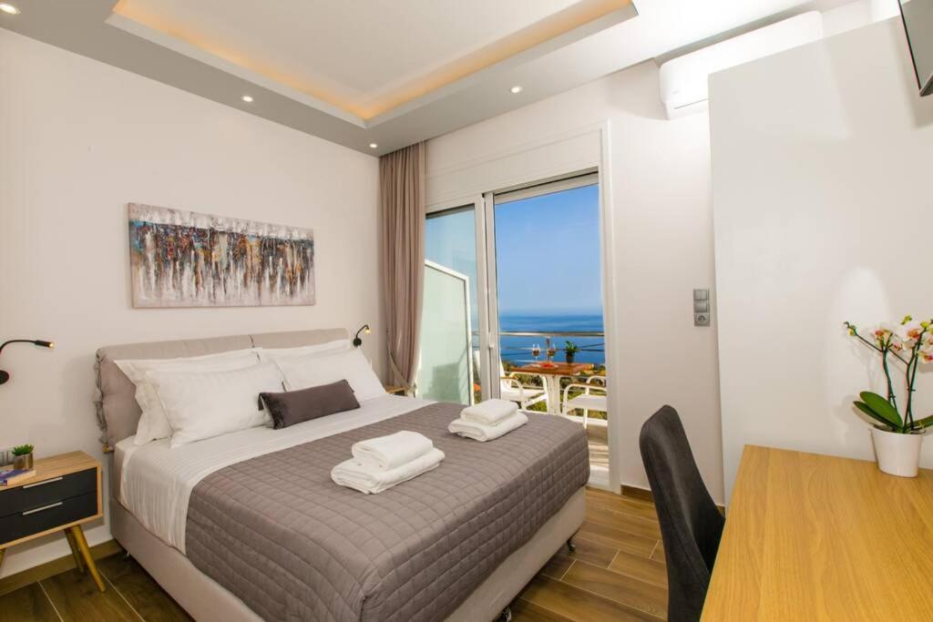 KeramesChrysi's Ocean View Retreat的一间卧室配有一张床、一张餐桌和一个窗户。
