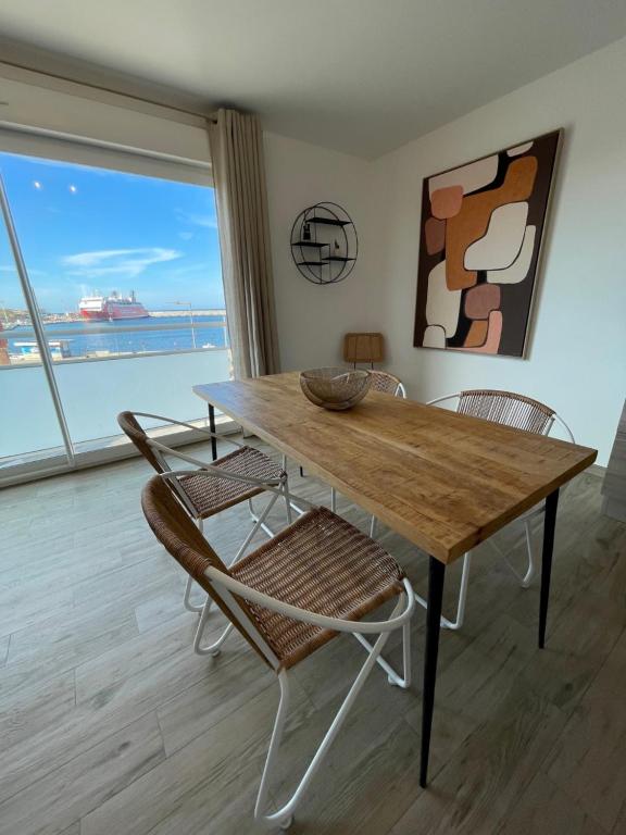 利勒鲁斯Residence Des Îles的餐桌、椅子和大窗户
