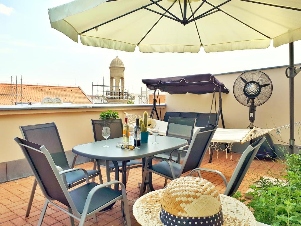 布达佩斯Rumbach Terrace Apartment的庭院配有桌椅和遮阳伞。