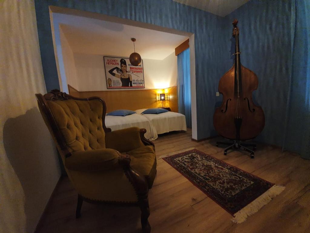 OlivoneCuore Alpino的一间设有吉他、椅子和床的房间