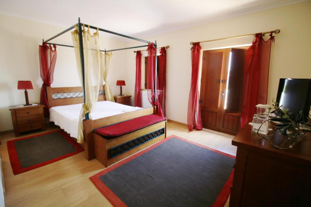 圣布拉什迪阿尔波特尔Paz e Natureza的一间卧室配有一张天蓬床和一台电视机