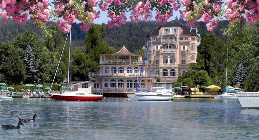 沃尔特湖畔佩莎赫阿斯托利亚酒店的湖上大房子,水中有船