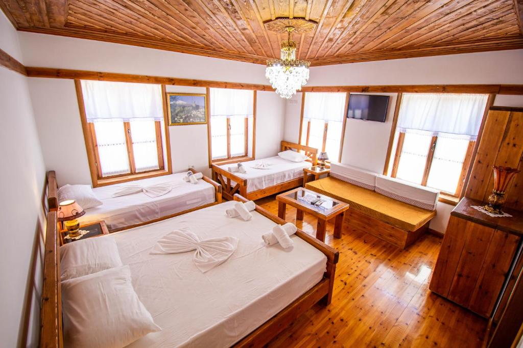 吉诺卡斯特Hotel Bebej Tradicional的一间卧室配有两张床和吊灯。
