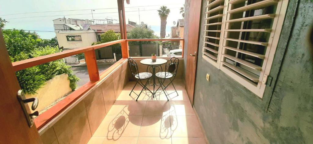 提比里亚דירת נופש במרכז טבריה的阳台配有桌椅。