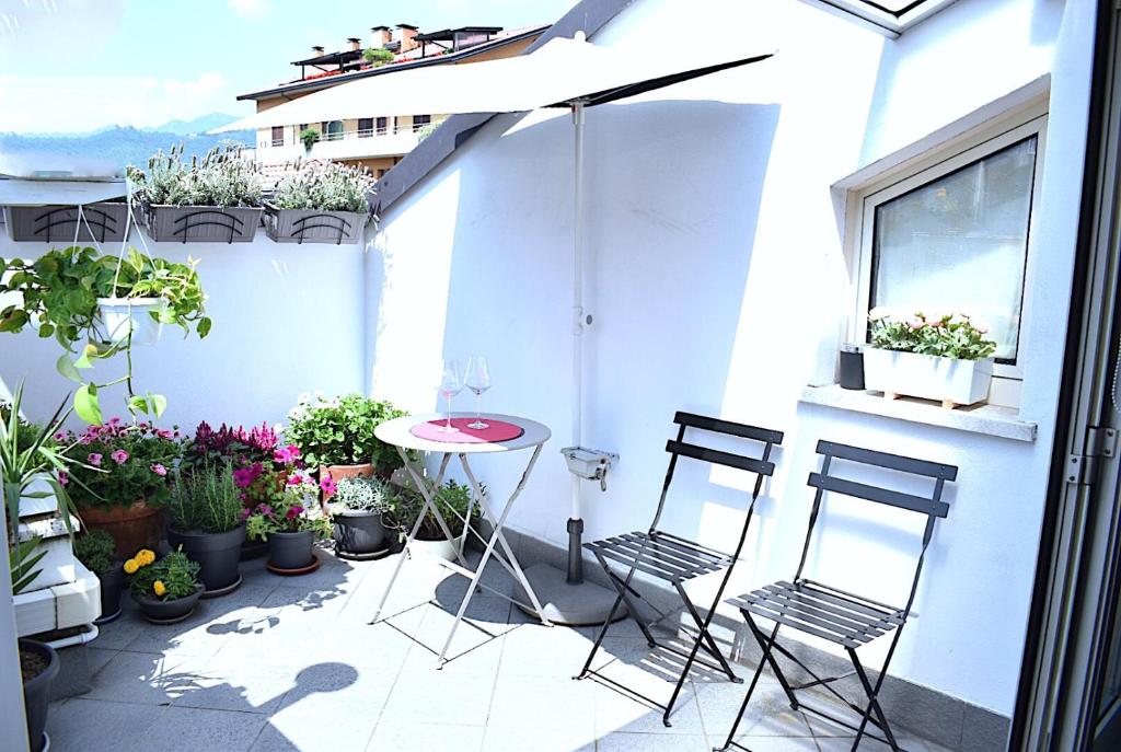 贝加莫Borgo d'Oro Loft的天井配有两把椅子、一张桌子和盆栽植物
