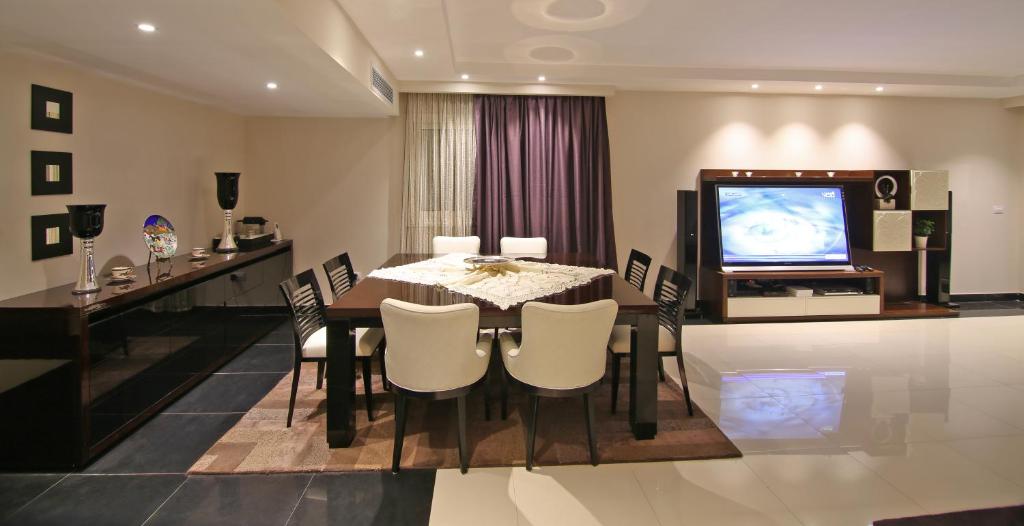 开罗AlAshrafia Smart Residence的一间带桌子和电视的用餐室