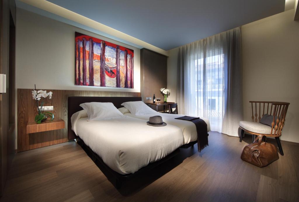 格拉纳达雷格赫达斯阿巴德斯酒店的一间卧室配有一张大床和一把椅子