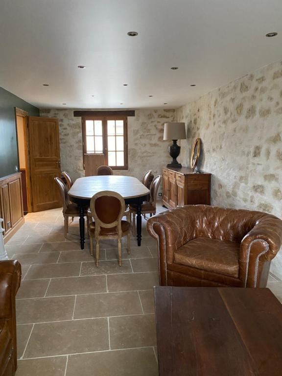 PontarméLa Maison du Caillou的客厅配有桌子和皮革家具