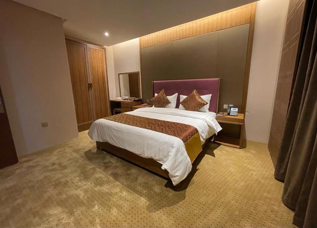 利雅德Hosta Hotel Suites的一间位于酒店客房内的带大床的卧室