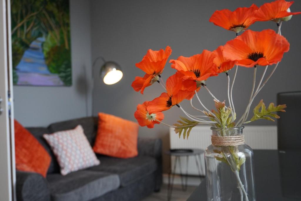 波塔当VIP Church View Apartment的客厅里装有橙花的花瓶