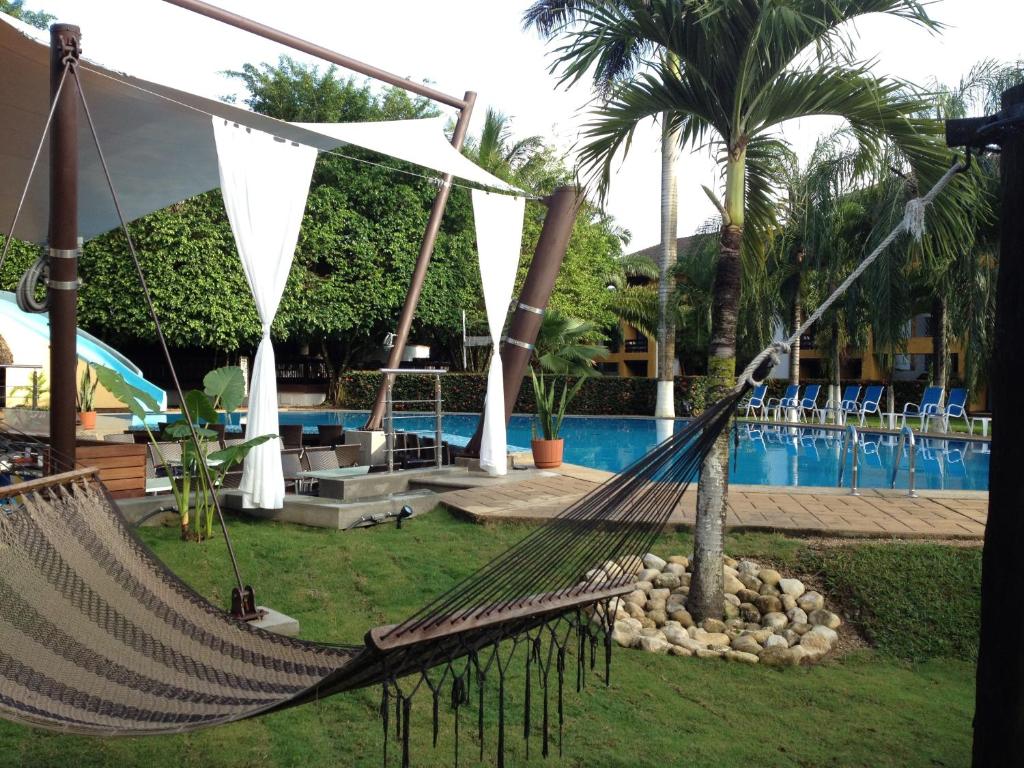 帕伦克帕伦克雷阿尔城酒店的游泳池前的吊床