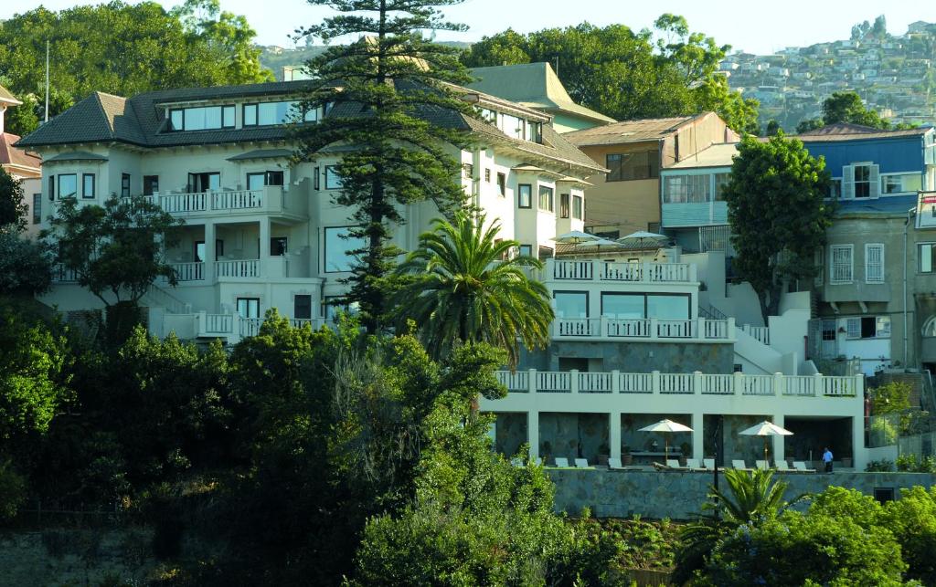 瓦尔帕莱索卡萨伊格拉斯酒店的前面有树木的白色大建筑
