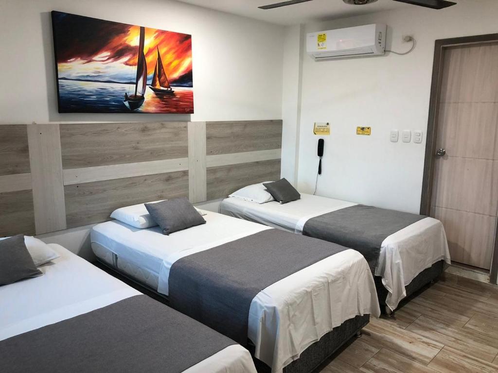 蒙特里亚Hotel ibiza Central的客房设有两张床和一台墙上的电视。