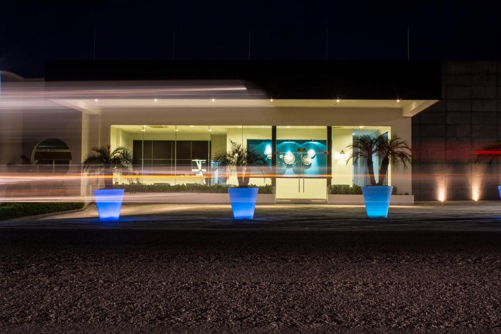 Martínez de La TorreHotel Aqua Spa & Resort的一座建筑,在晚上前有蓝色的锅