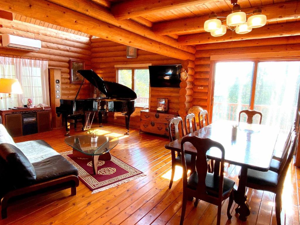 KannamiA Private Log House with Mt Fuji View & Piano - "Thangtong House Japan"的客厅配有桌子和钢琴