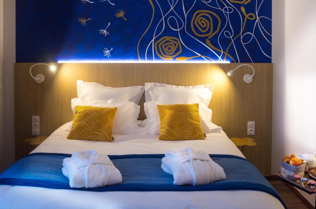 珀莱维尔Kyriad Prestige Amiens Poulainville - Hotel and Spa的一间卧室配有一张床,上面有两条毛巾
