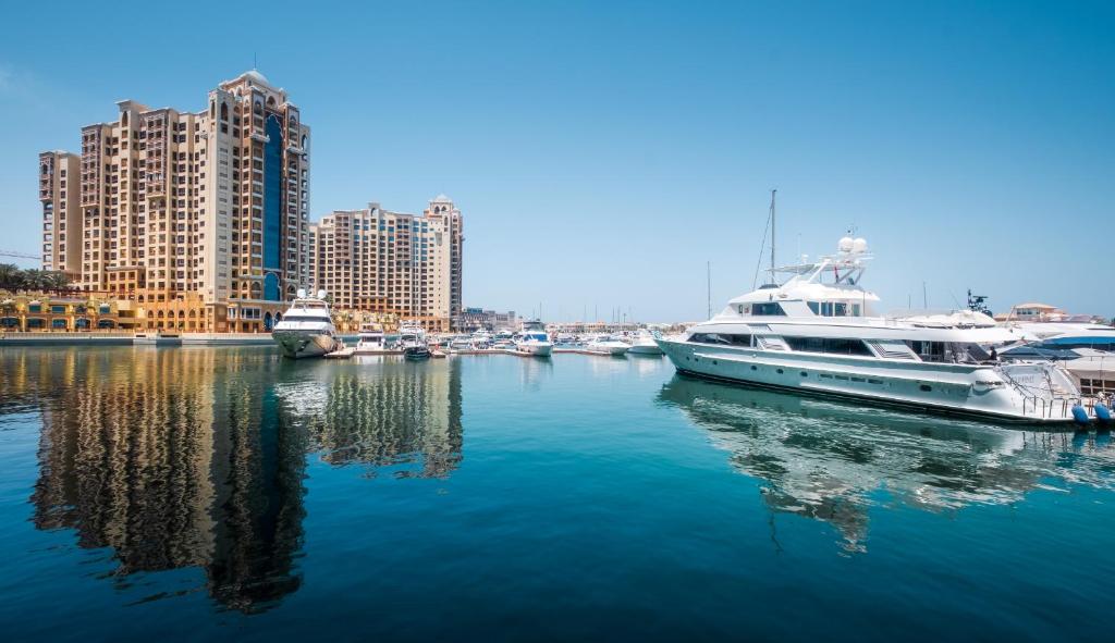 迪拜Maison Privee - Tiara Diamond G06的一群船停靠在港口,有建筑物