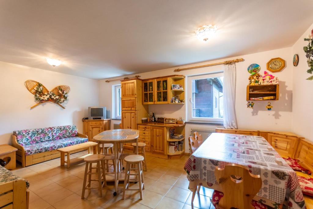 索拉加Residence Sas de le Undesc的厨房以及带桌椅的起居室。