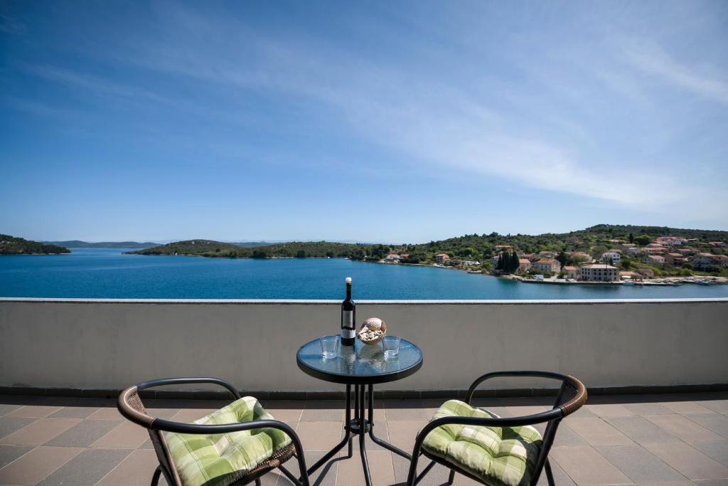 Luka皮奇奇酒店的阳台上的玻璃桌、两把椅子和一瓶葡萄酒