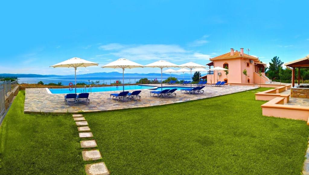 卡拉内拉卡拉挪拉全景公寓式酒店的草坪上带椅子和遮阳伞的游泳池