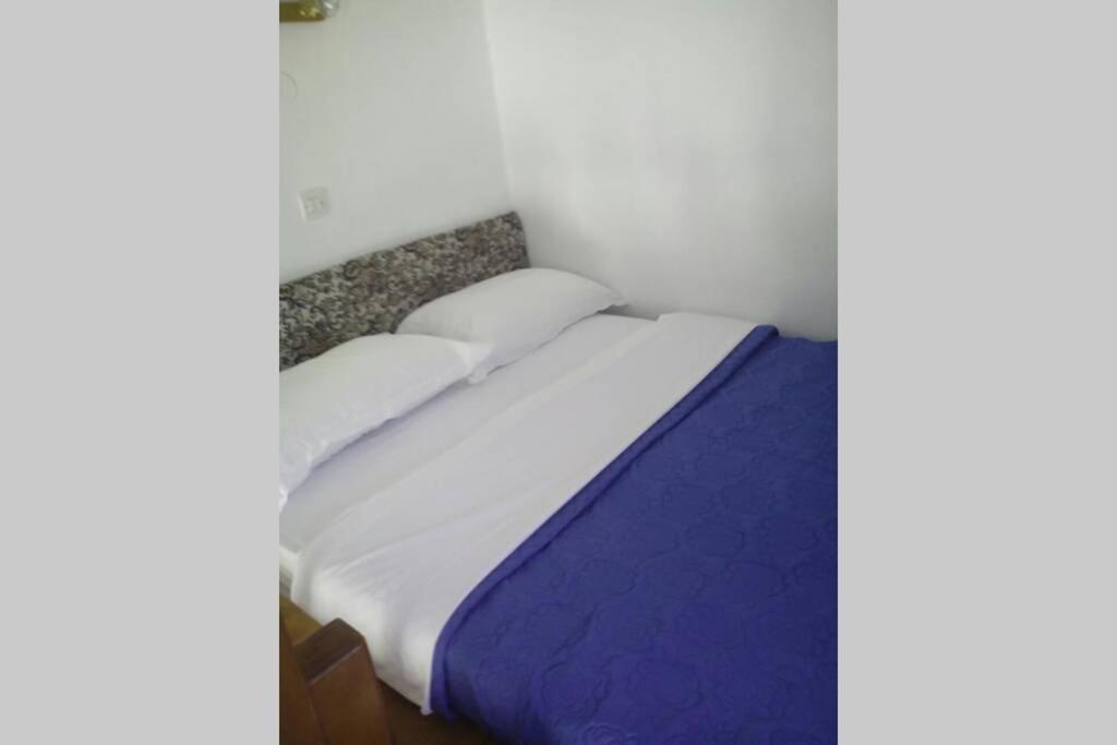 帕特莫斯Sunset Apartment的一张带白色床单和枕头的床