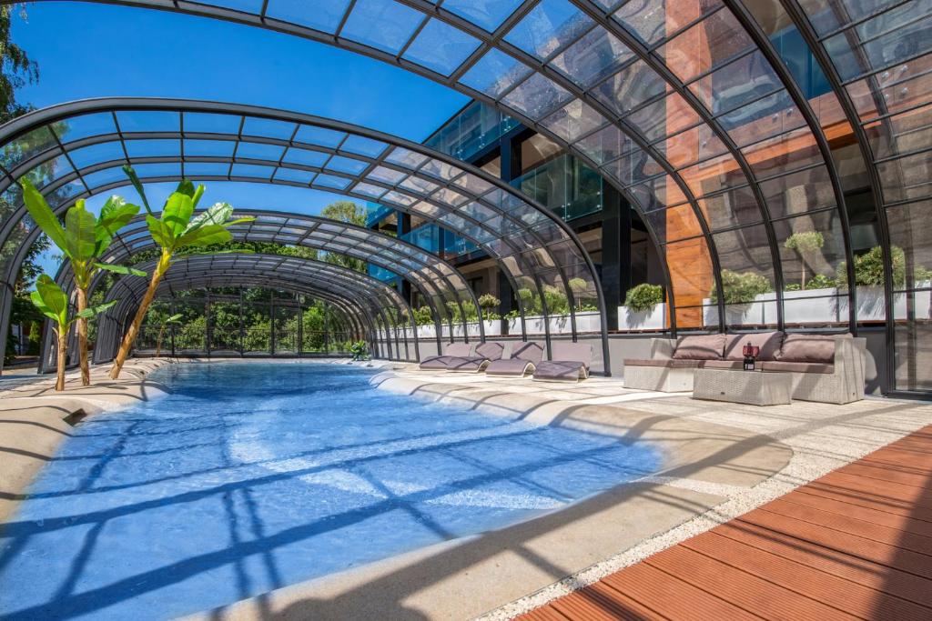 库瑞尼卡慕斯卡Port 21 Pura Pool & Design Hotel - Adults Only的一座带玻璃天花板的建筑中的游泳池