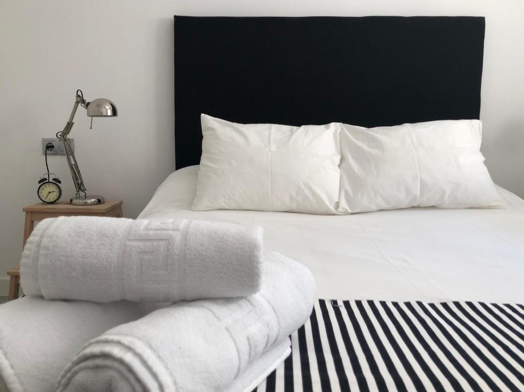 拉斯内格拉斯Apartamento Algazul的一张带黑色床头板和白色枕头的白色床