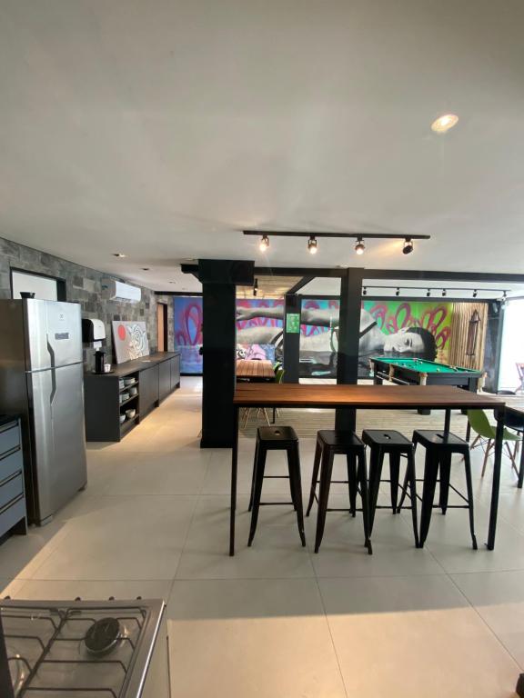 弗洛里亚诺波利斯Innbox - Canasvieiras 2的厨房配有桌子、椅子和冰箱。