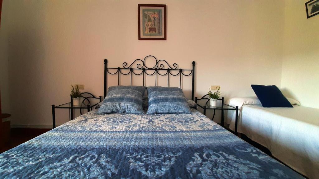 BarciaCASA LA REVERENDA的一间卧室配有一张带蓝色棉被的床