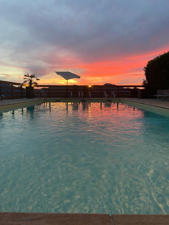 TrévigninLogis Hôtel Le Bellevue的一座享有日落美景的大型游泳池