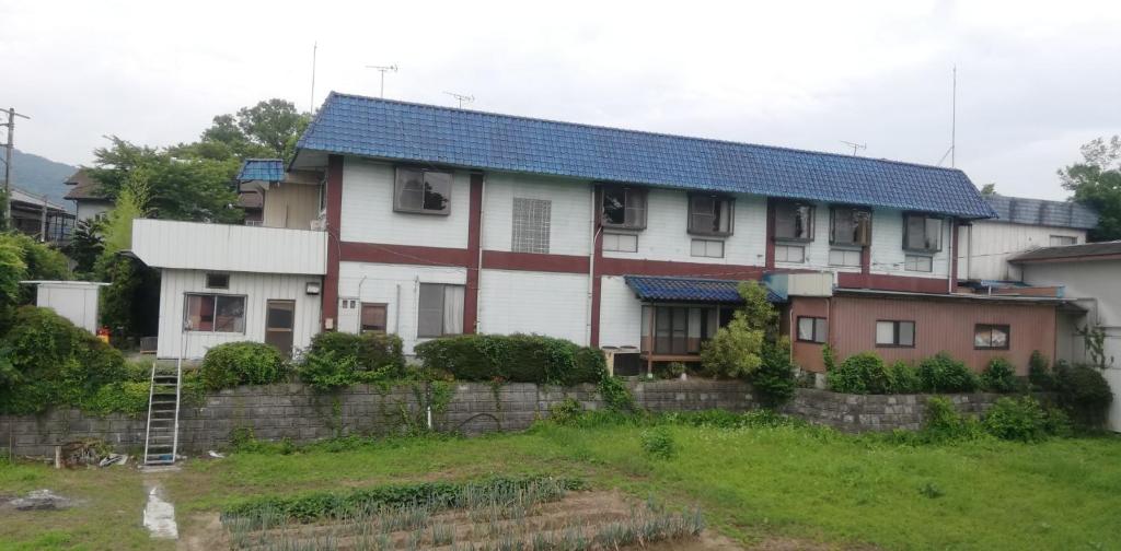 秩父市Suijin Hotel - Vacation STAY 38314v的蓝色屋顶和庭院的白色房子