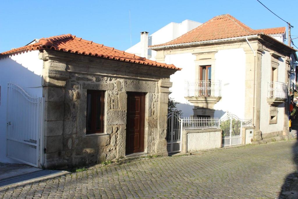 Moimenta da SerraCasa Bento Moura Portugal的白色建筑旁的街道上的古老建筑