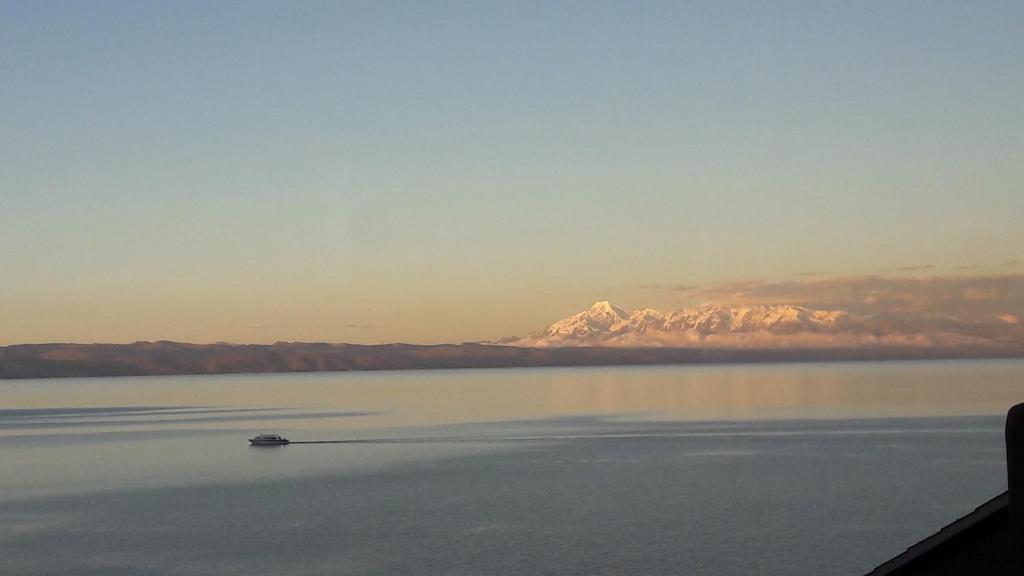 Isla de SolJACHA INTI的水中的小船,背景是山