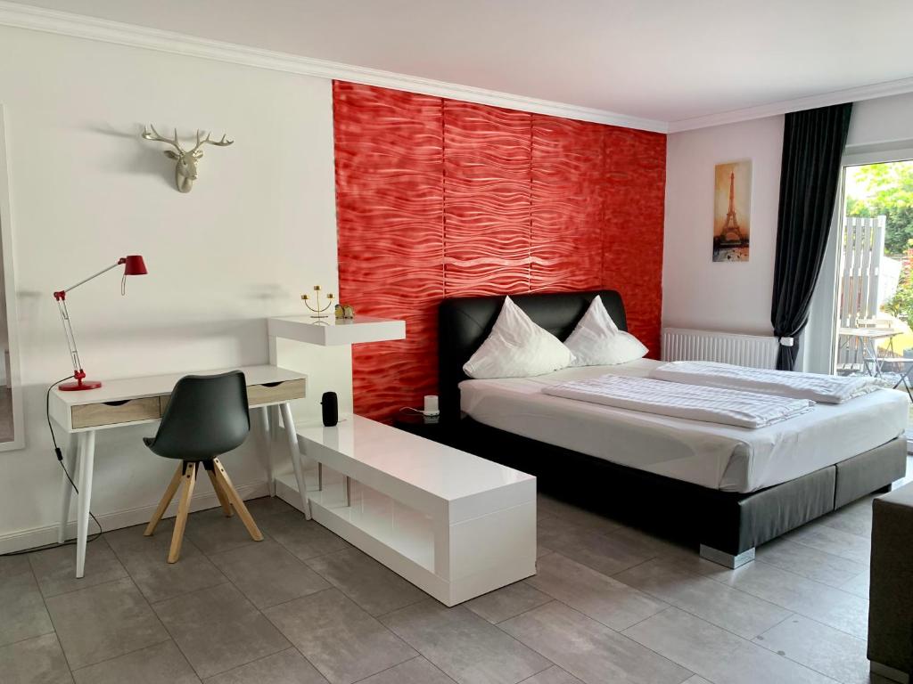 汉诺威Apartment Martinstraße 7b的一间卧室配有一张带书桌的床和红色的墙壁