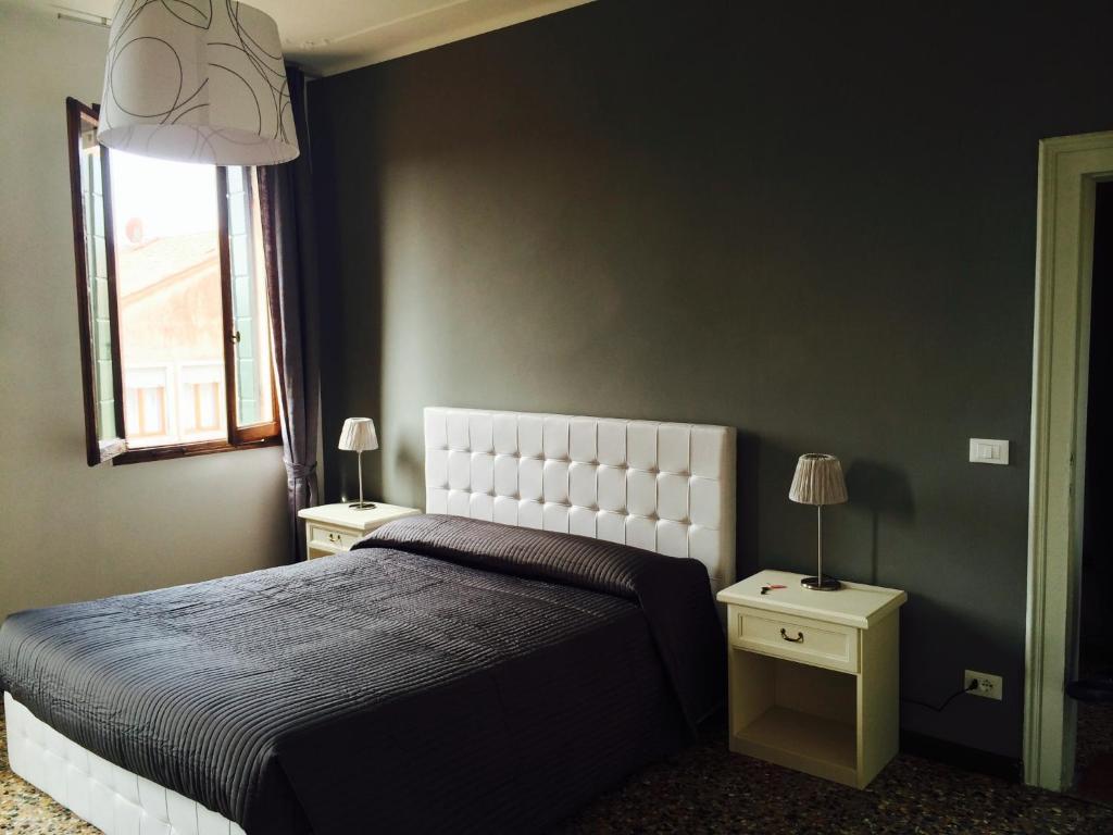 威尼斯科尔特罗利达纳旅馆的一间卧室设有一张大床和两个床头柜