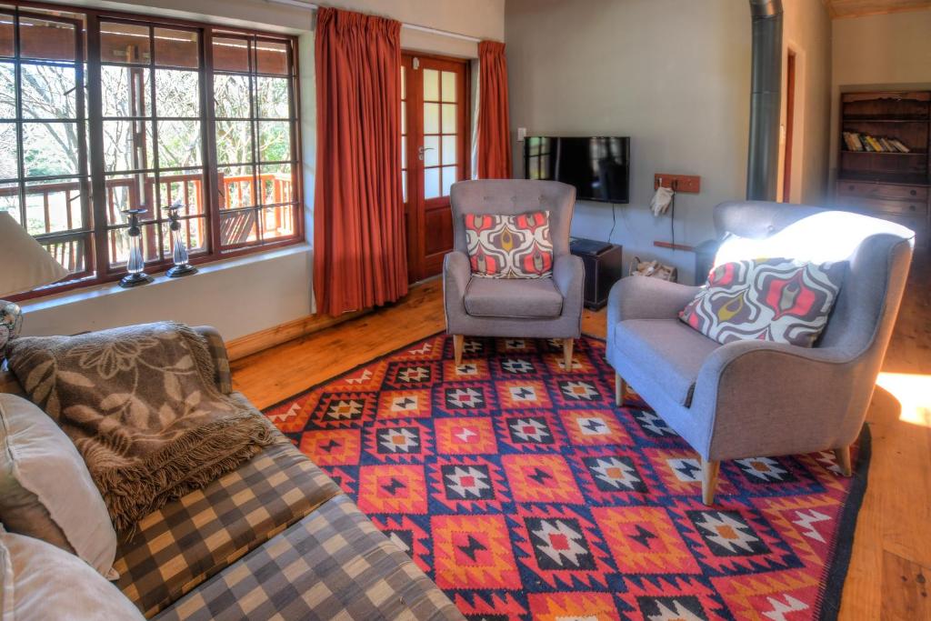 豪格斯拜克Laragh-on-Hogsback的客厅配有沙发、两把椅子和地毯