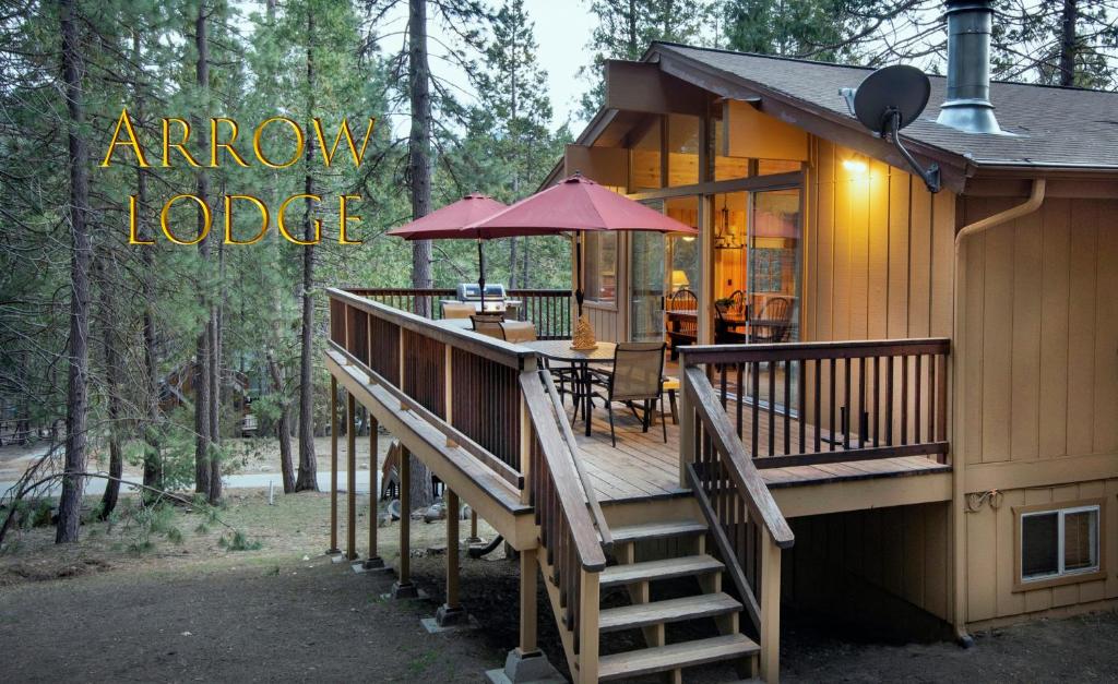 瓦沃纳Arrow Lodge的房屋设有1个带桌子和遮阳伞的甲板