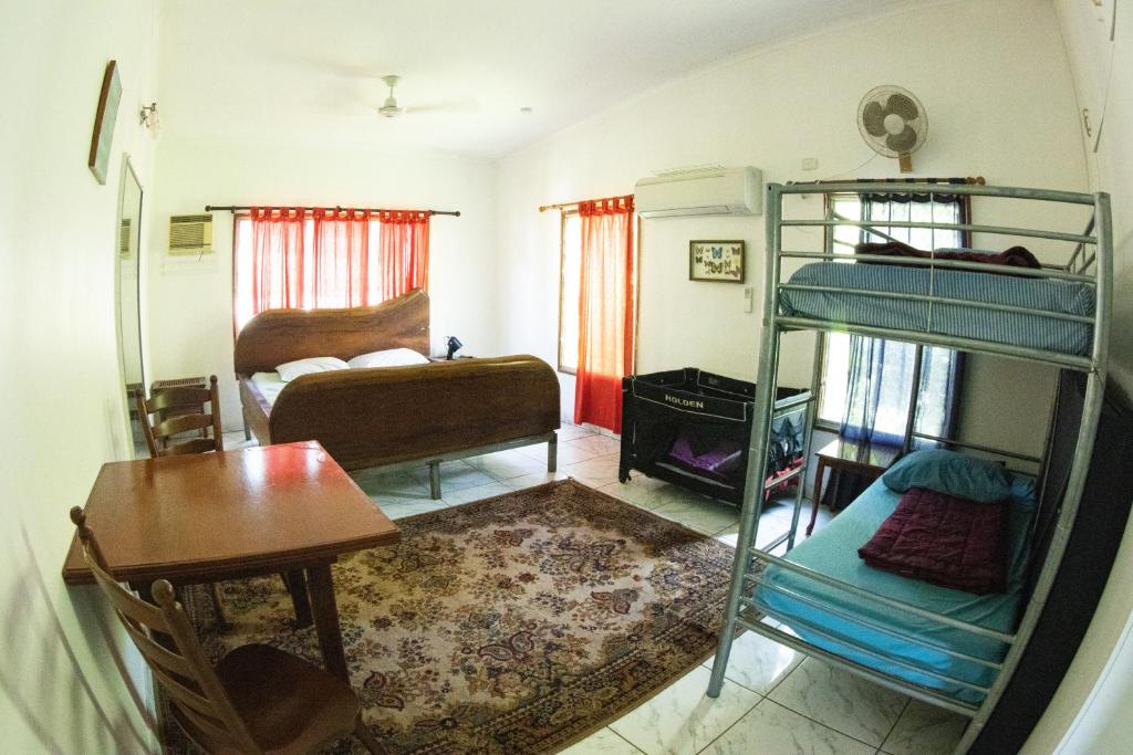 Batchelor巴切勒蝴蝶农场酒店的客房设有两张双层床、一张桌子和一张书桌。