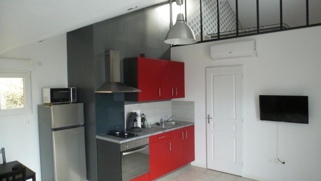沙斯讷伊迪普瓦图Logements Le232 fr的一间带红色橱柜和冰箱的厨房