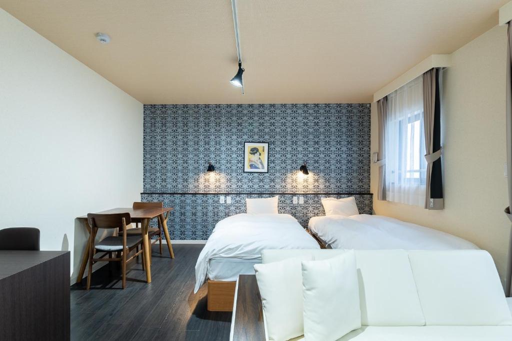 东京VACATION INN HEIWAJIMA 1 - Vacation STAY 10876的酒店客房设有两张床和一张桌子。